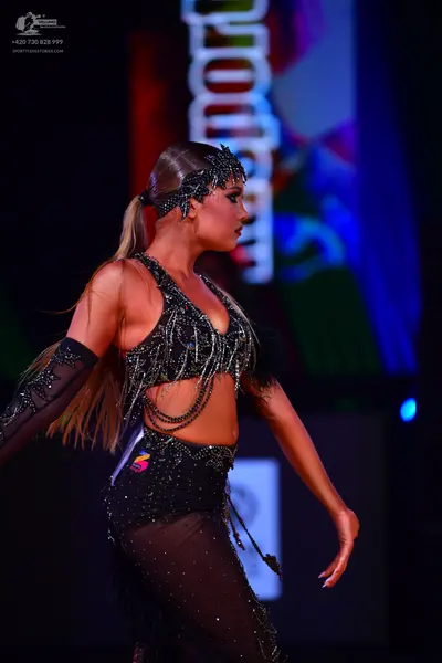 Dancesport competitor: Female dancer: black Latin dance costume featuring a sequined and crystal-embell