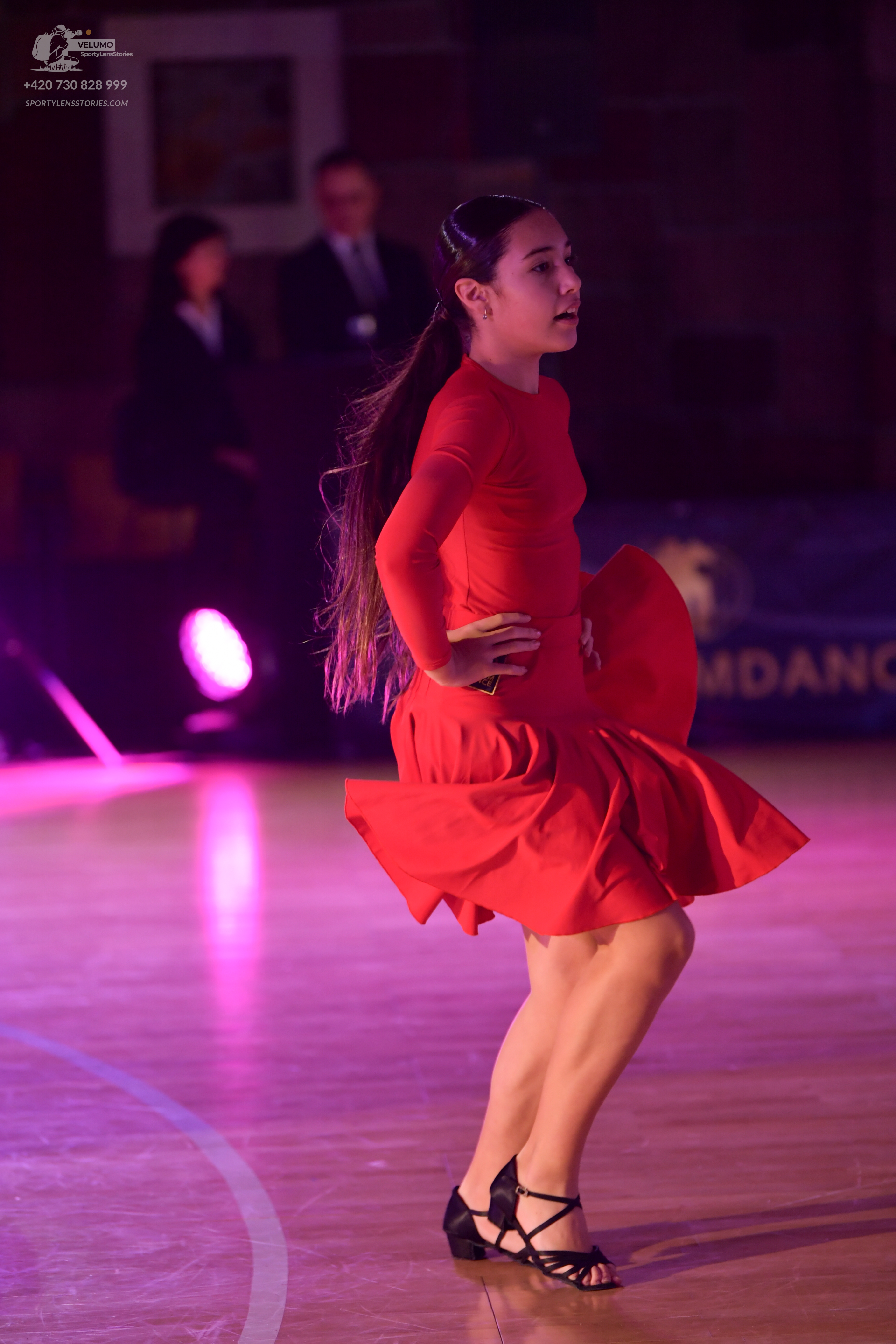 Dancesport competitor: Female dancer: red long-sleeved Latin dress with a flared skirt
