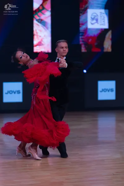 Dancesport competitor: Female dancer: red latin dress with many layers of ruffles