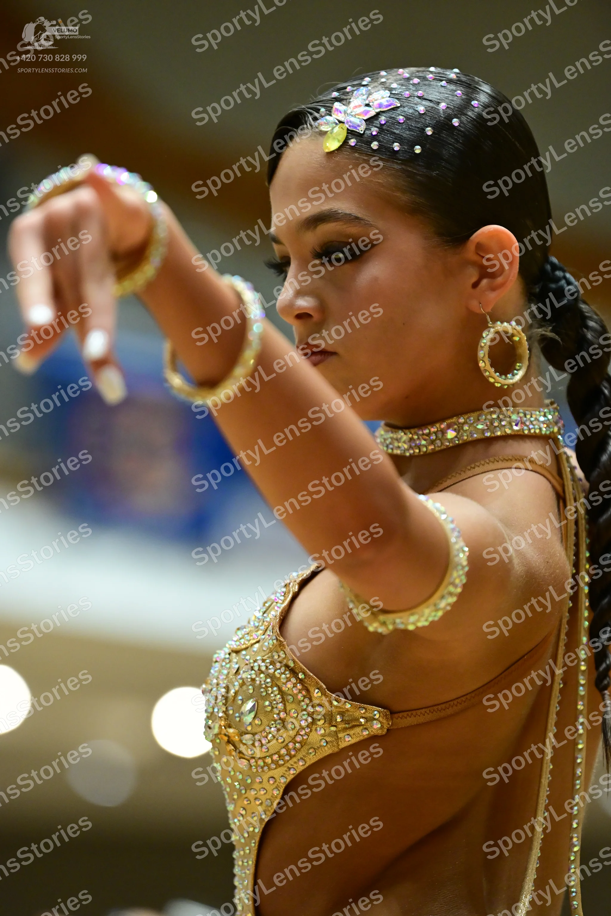 Dancesport competitor: Female dancer: gold Latin dance costume heavily embellished with rhinestones and