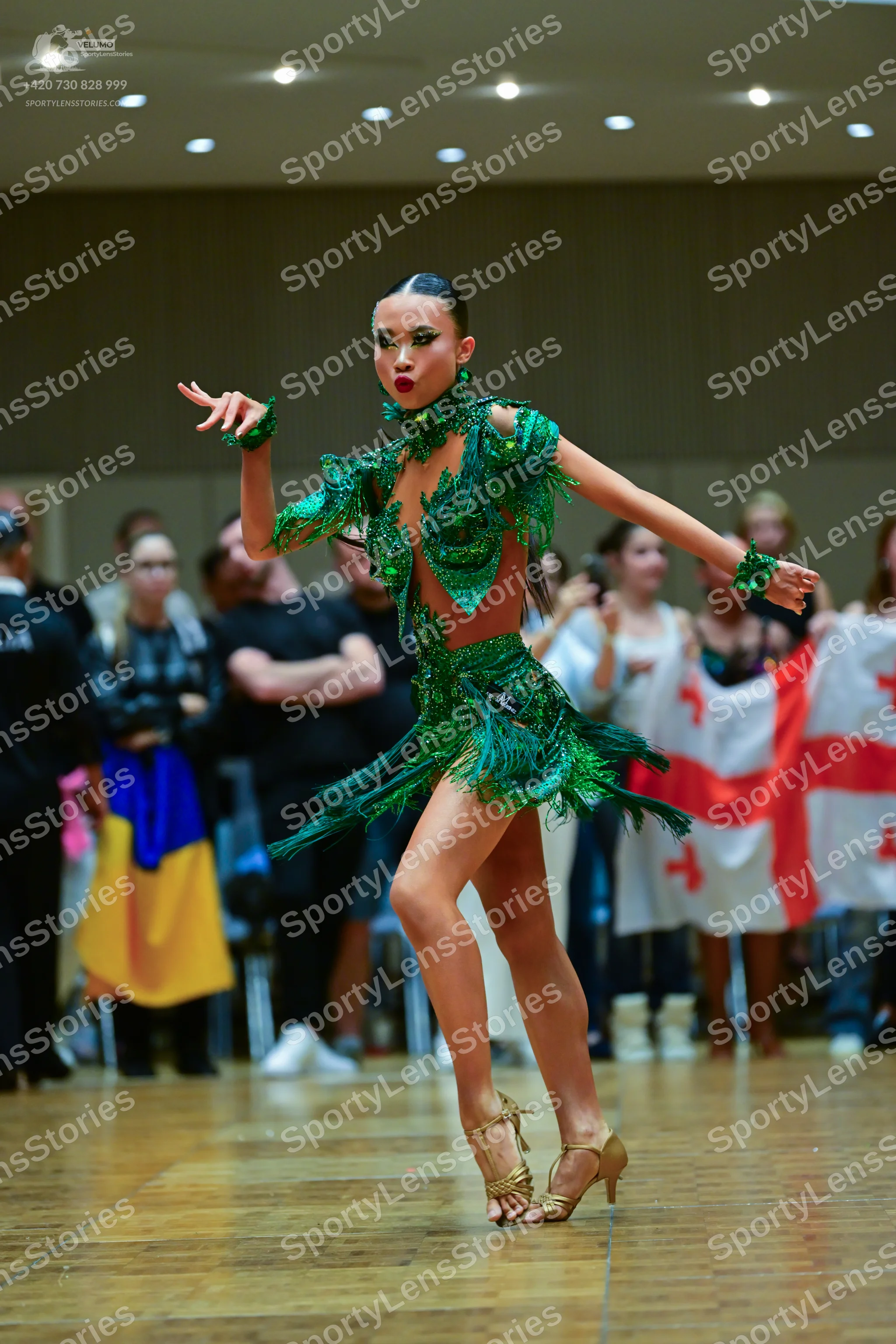 Dancesport competitor: Female dancer: green latin dress with sequins and fringe