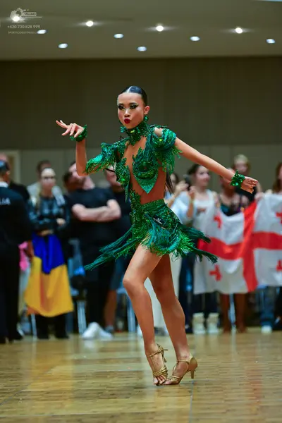 Dancesport competitor: Female dancer: green latin dress with sequins and fringe
