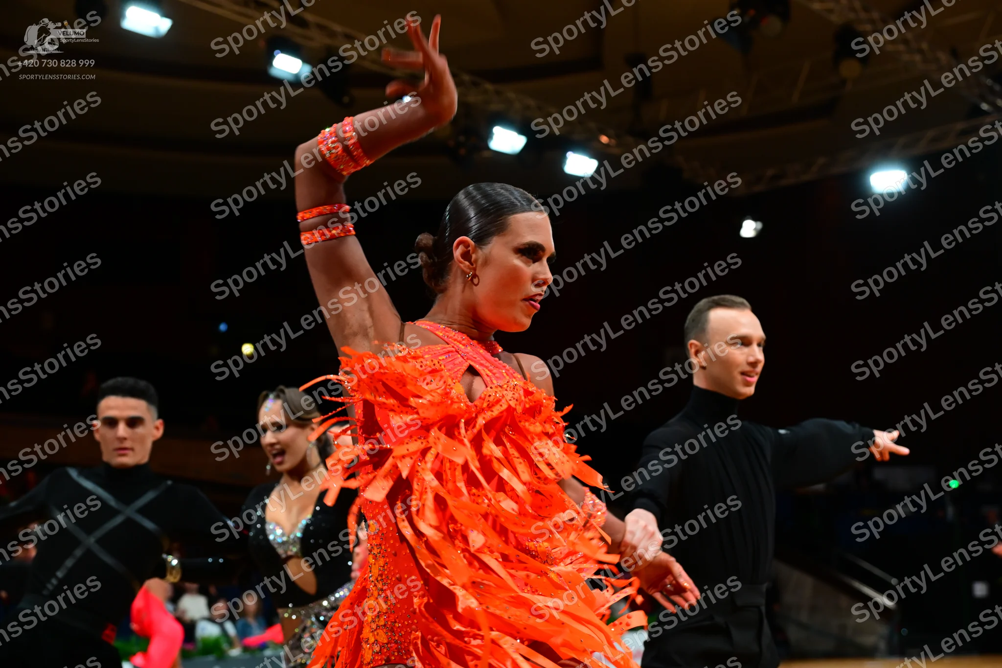 Dancesport competitor: Main female dancer: bright orange Latin dress with long, thick fringe and matchi