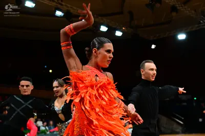 Dancesport competitor: Main female dancer: bright orange Latin dress with long, thick fringe and matchi