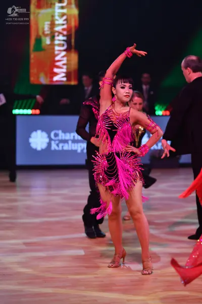 Dancesport competitor: Female dancer: pink latin dress with long fringe and sequins, with matching pink