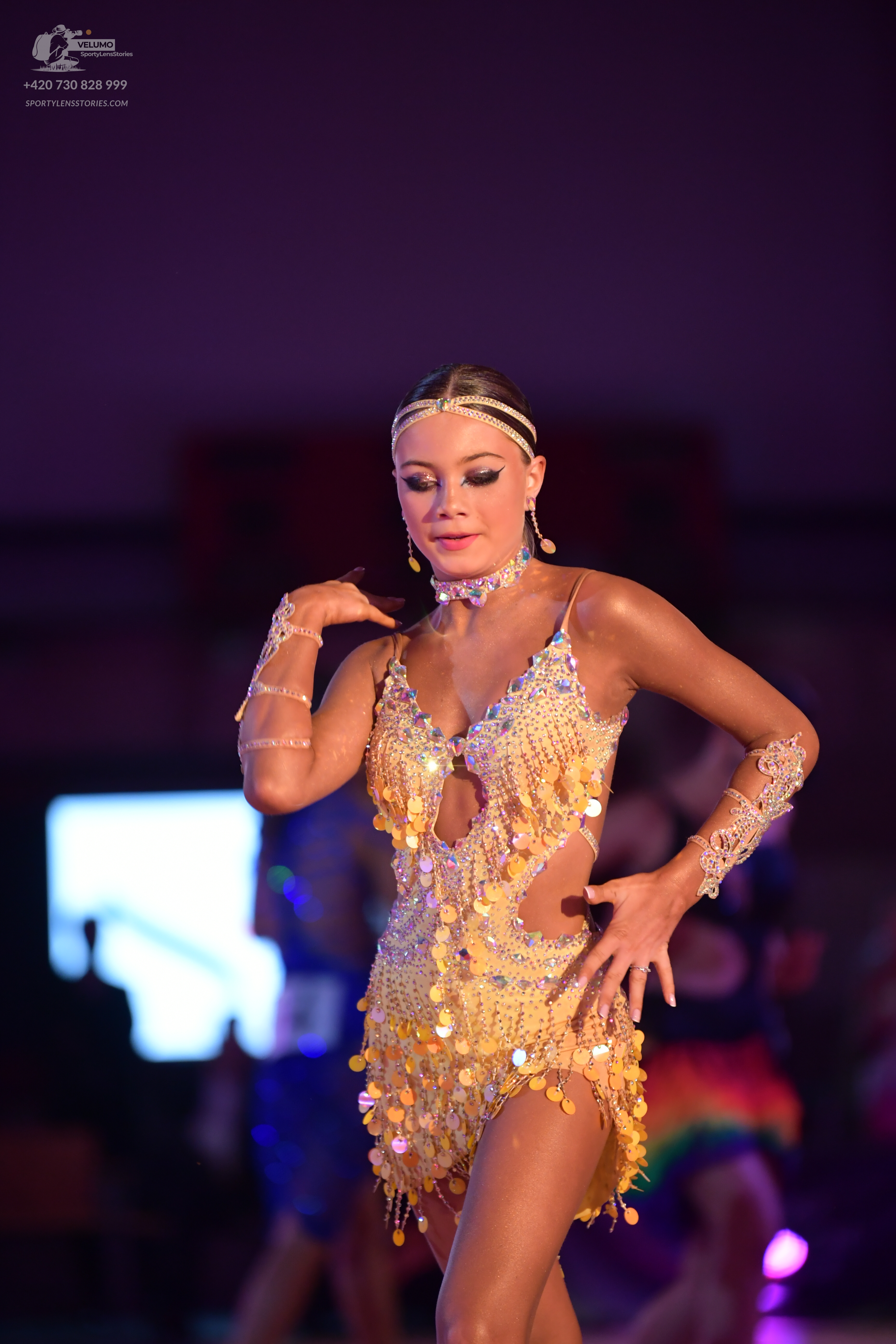 Dancesport competitor: Female dancer: gold latin dress with sequins, crystals, and large gold paillette