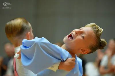 Dancesport competitor: Female dancer: light blue satin gown with voluminous puff sleeves