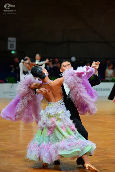 Dancesport competitor: Female dancer: voluminous ballroom gown with a layered, ruffled skirt in lavende