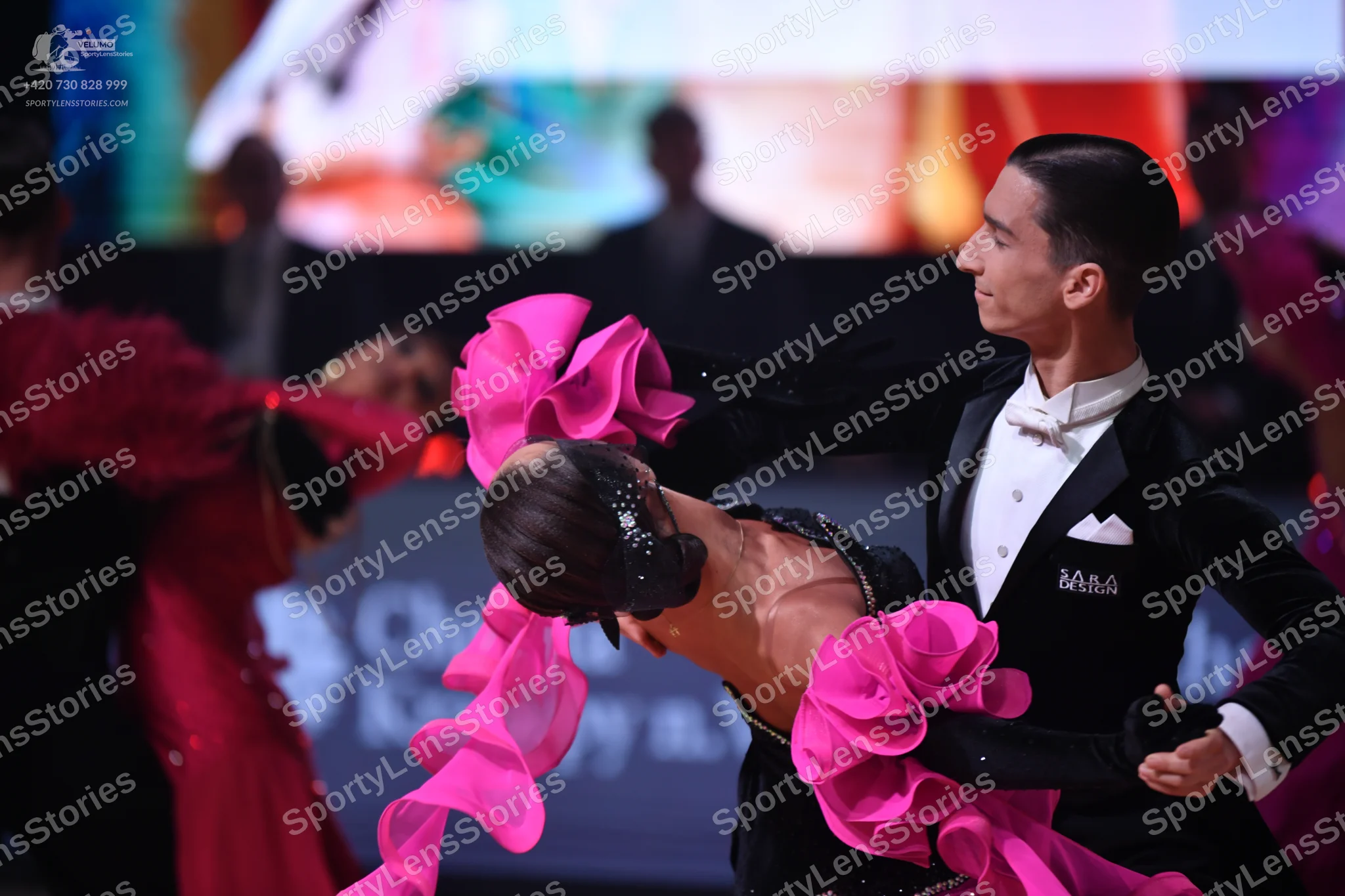 Dancesport competitor: Male dancer: black suit with a white shirt, white bowtie, and white pocket squar