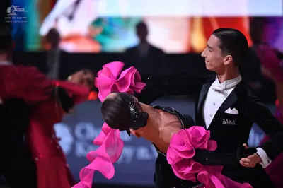 Dancesport competitor: Male dancer: black suit with a white shirt, white bowtie, and white pocket squar