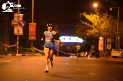 Marathon runner #4125: Runner 1: light blue tank top, dark shorts, white visor, dark arm sleeves, white