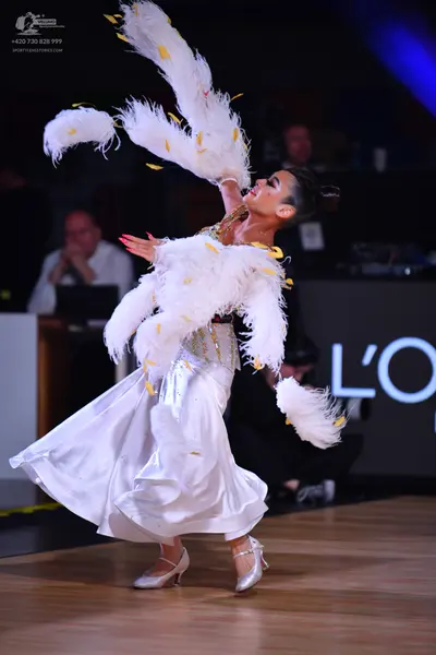Dancesport competitor: Female dancer: white ballgown with a voluminous skirt and large white feather ac