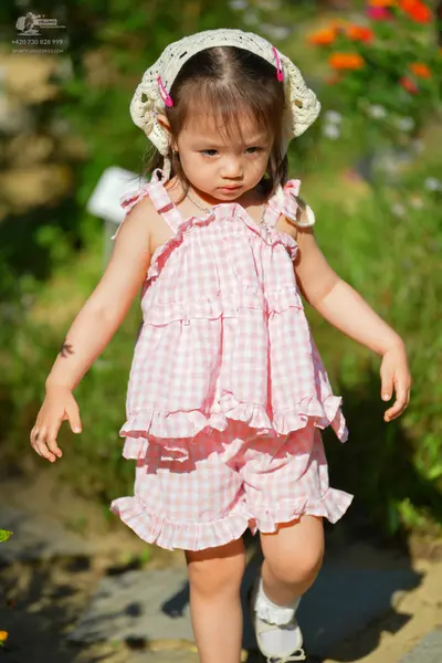 Dancesport competitor: Female dancer: pink and white gingham sleeveless top and shorts set with ruffles