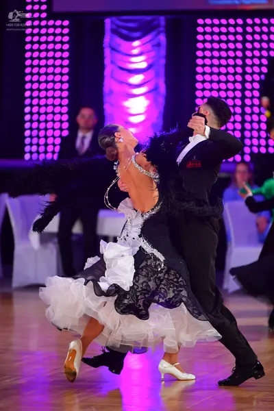 Dancesport competitor: Male dancer: black suit with black feather trim on the sleeves