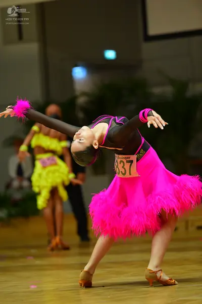 Dancesport competitor #837: Female dancer: black and bright pink Latin dance dress with long sleeves and a v