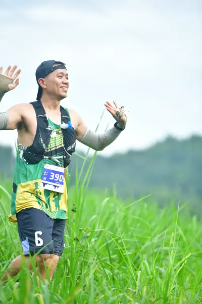Marathon runner #390: Runner 1: black tank top with green and yellow patterns, dark shorts with a whit