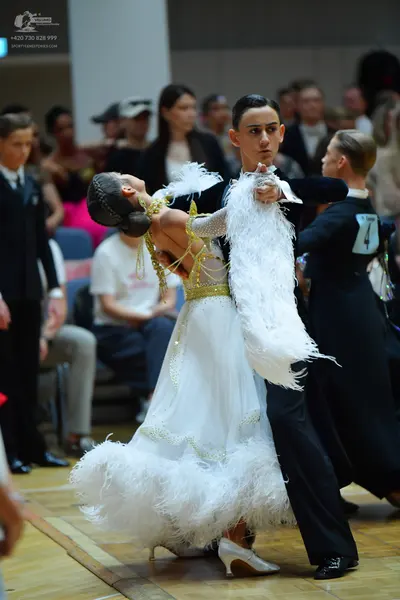 Dancesport competitor: Main female dancer: white ballgown with white feathers and gold sequin embroider