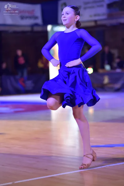 Dancesport competitor: Female dancer: blue, long-sleeved, solid-colored dance dress with a flared, ruff