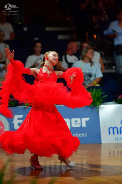 Dancesport competitor: Female dancer: red latin dress with long red fringe