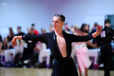 Dancesport competitor: Male dancer: black long-sleeved Latin dance top with a deep V-neck