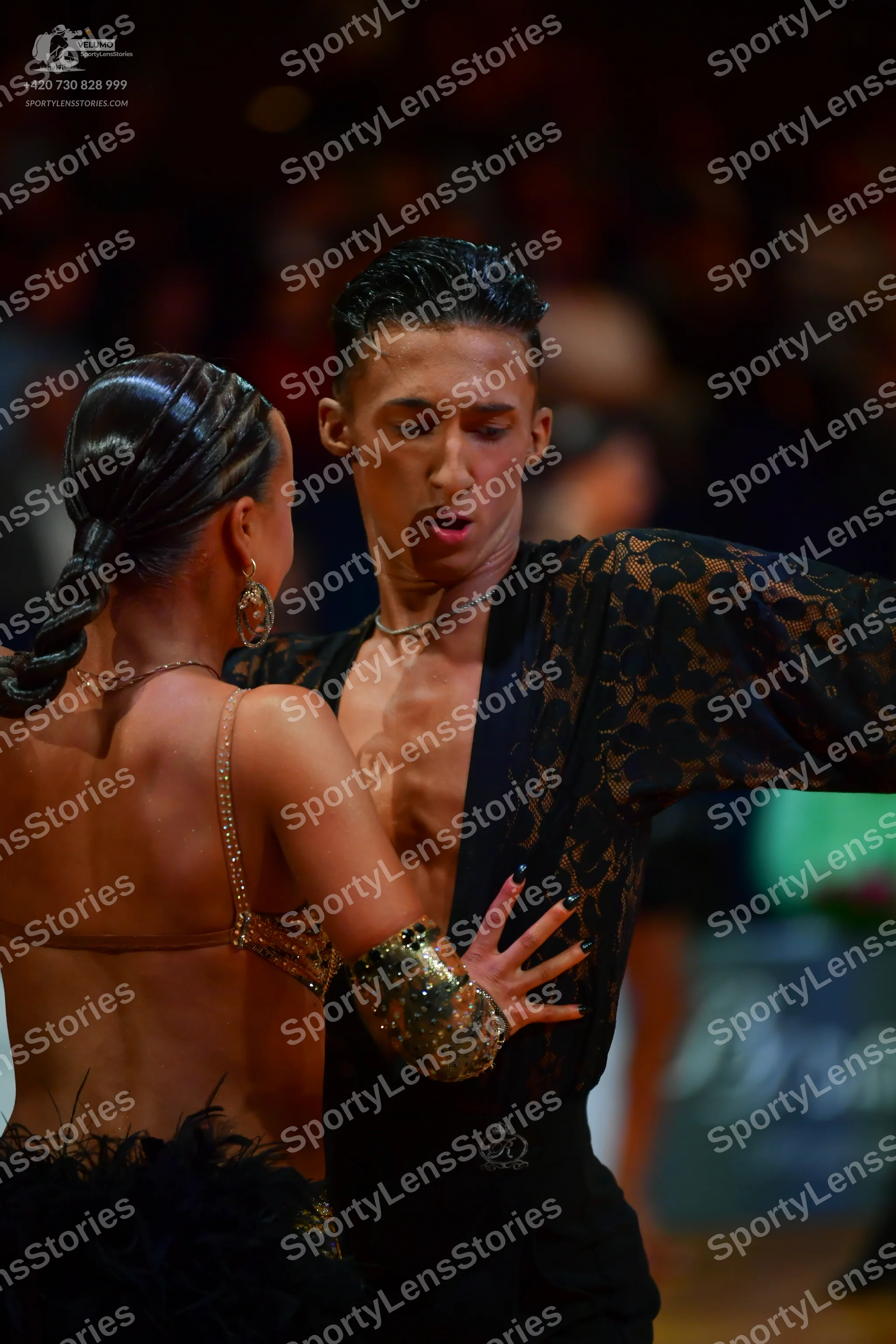Dancesport competitor: Male dancer: black shirt with lace-patterned sleeves, worn open at the chest, an