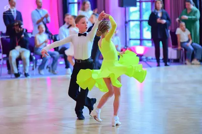 Dancesport competitor: Male dancer: white long-sleeved shirt with a black bowtie and black trousers