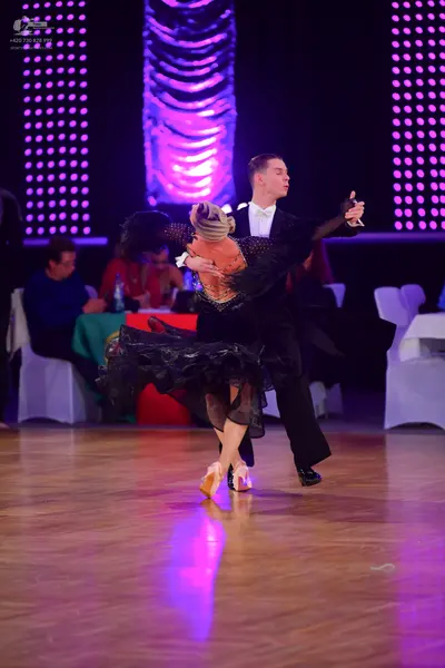 Dancesport competitor: Male dancer: black suit with a white shirt and a white bowtie