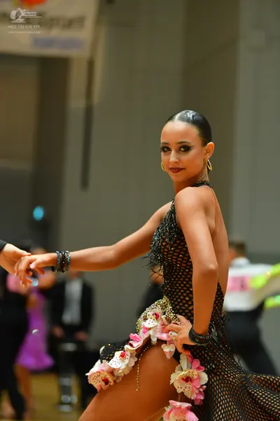 Dancesport competitor: Main female dancer: black mesh latin dress with pink and white floral appliques,