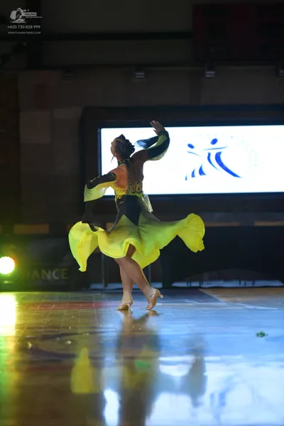 Dancesport competitor: Female dancer: lime green and black latin dress with a flowing skirt and embelli