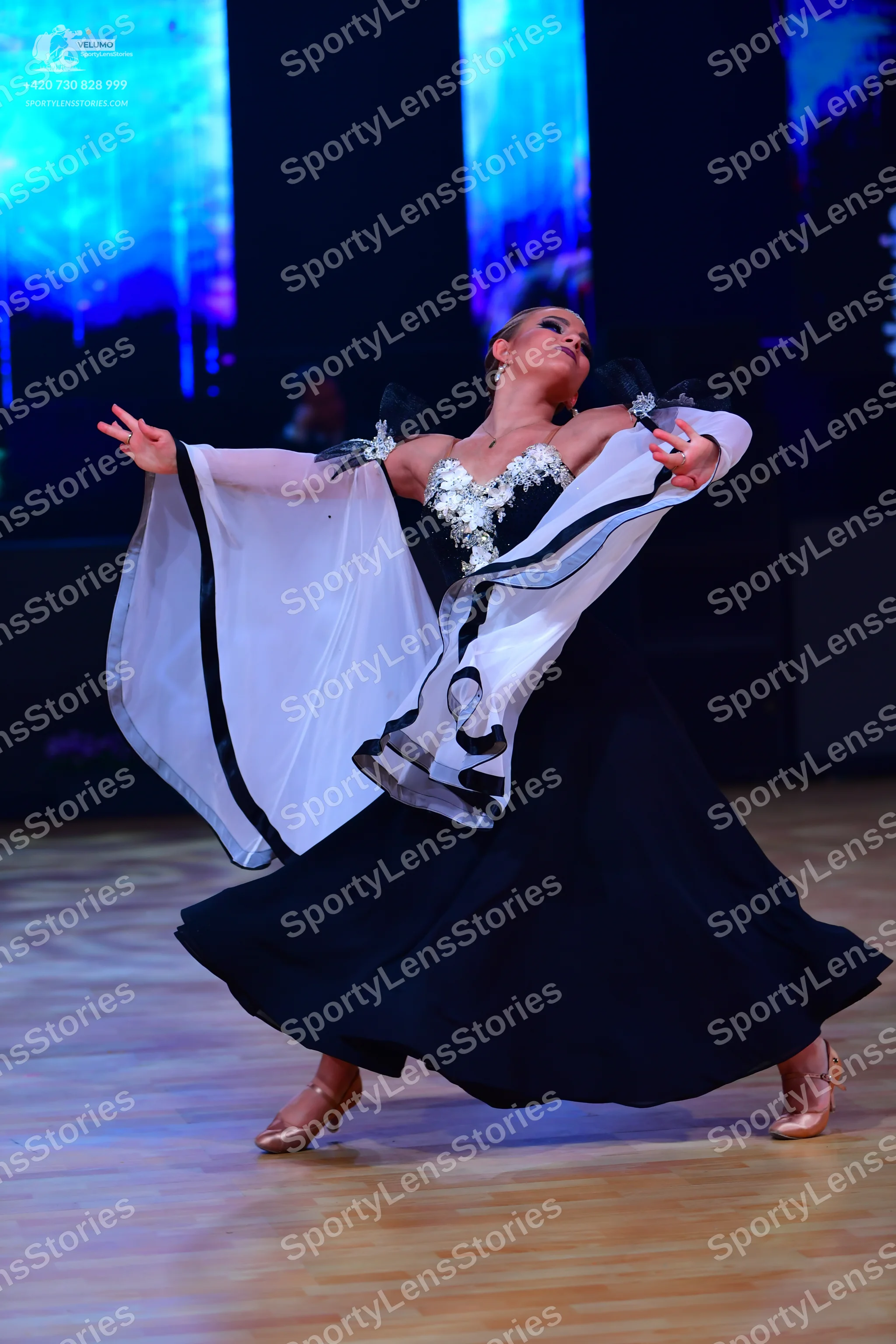 Dancesport competitor: Female dancer: black ballgown with a white and black accented bodice and large,