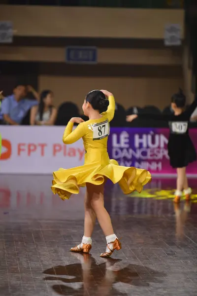 Dancesport competitor #87, #107: Female dancer 1: yellow latin dress with long sleeves and a flowing skirt
