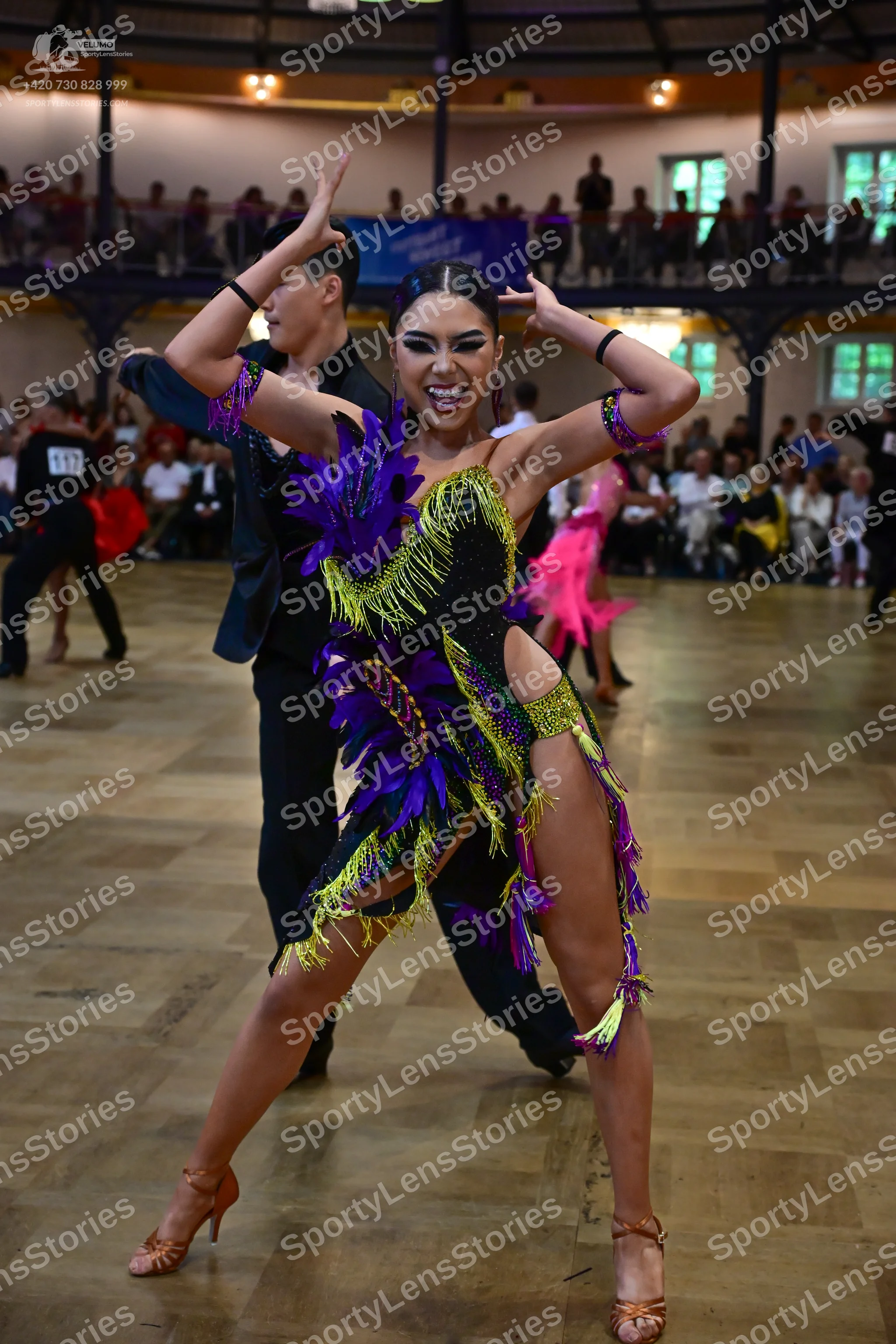 Dancesport competitor #917: Female dancer: black Latin dance dress with purple, lime green, and yellow sequi