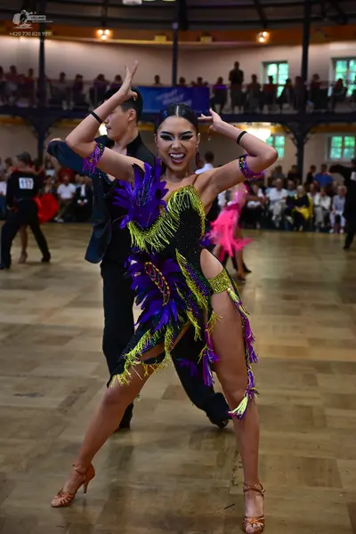 Dancesport competitor #917: Female dancer: black Latin dance dress with purple, lime green, and yellow sequi