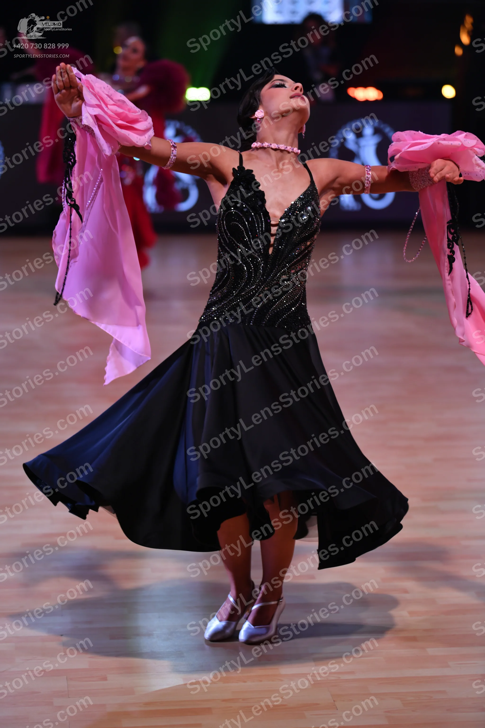 Dancesport competitor: Female dancer: black latin dress with a sequined bodice and a flowing black skir