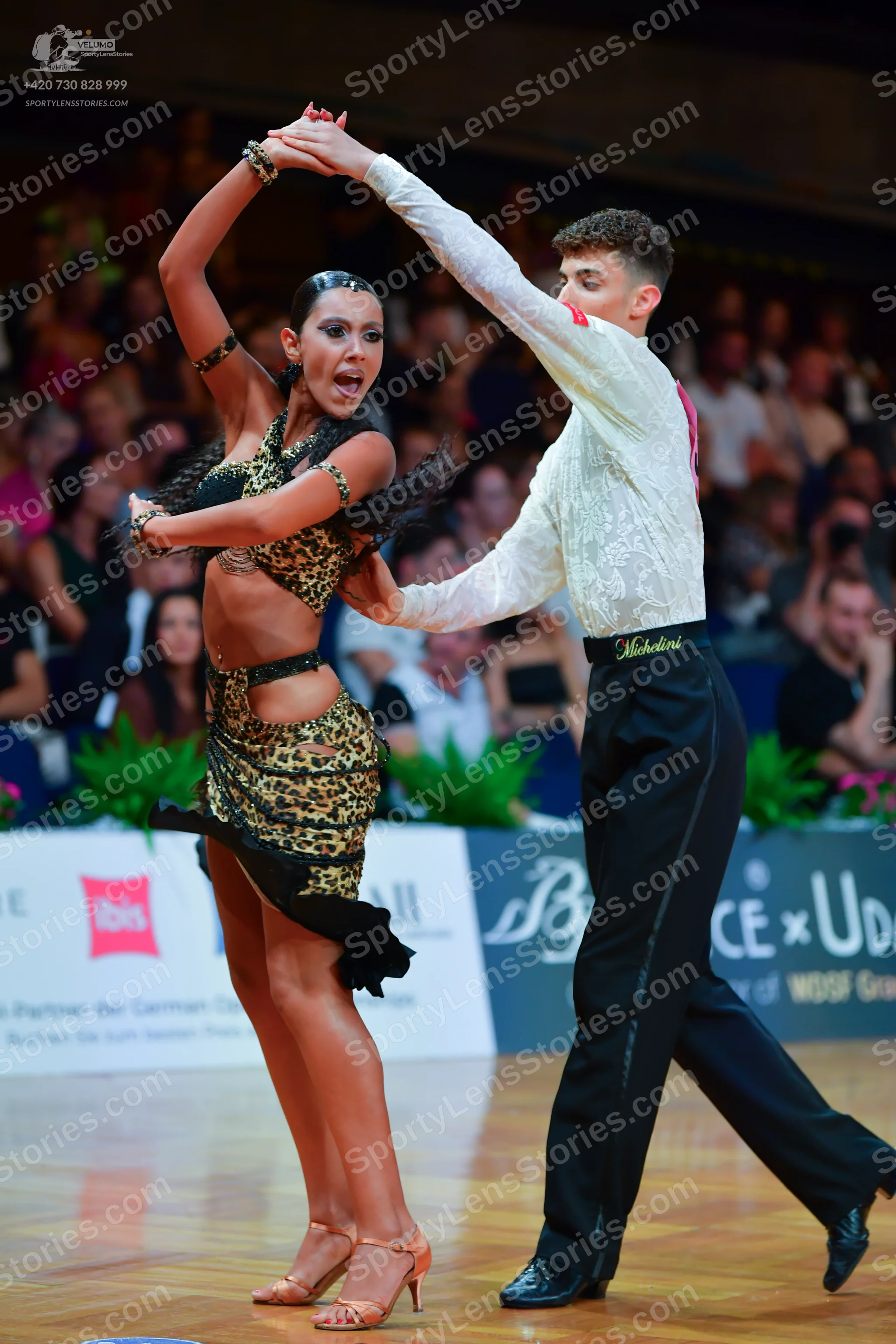 Dancesport competitor: Female dancer: leopard print two-piece Latin costume with a halter top and a mat