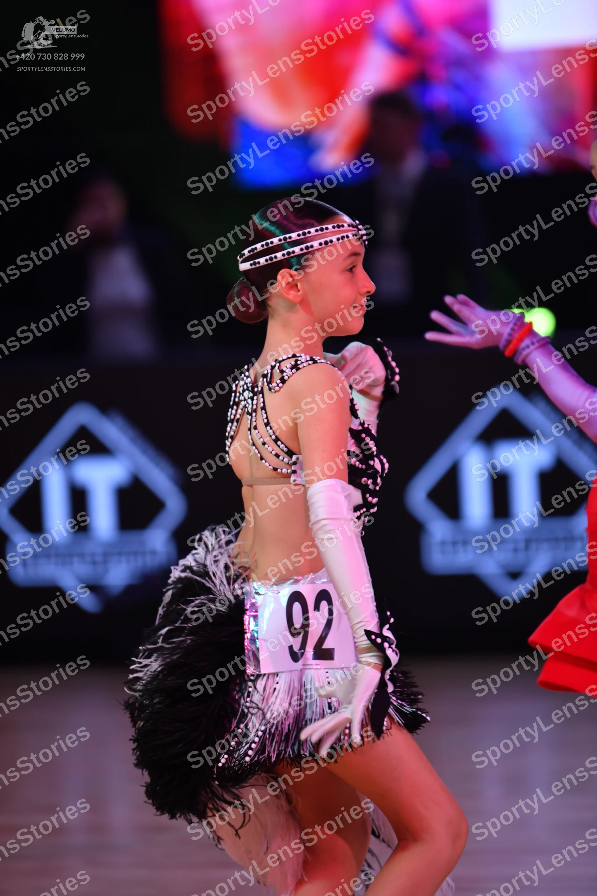Dancesport competitor: Female dancer: white and black Latin dress with sequins and long fringe, white l