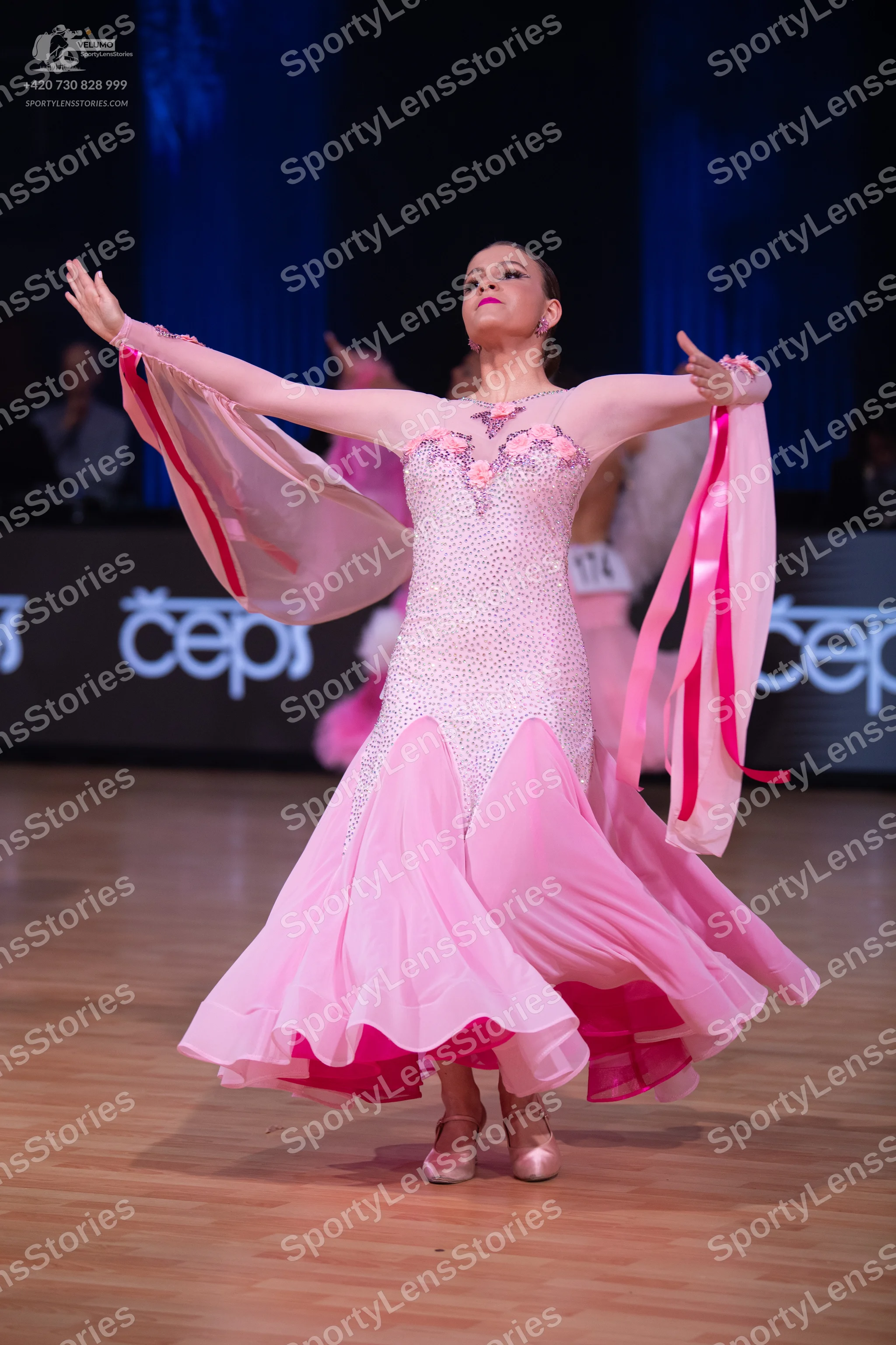 Dancesport competitor: Female dancer: light pink ballroom gown with a heavily sequined bodice, floral e