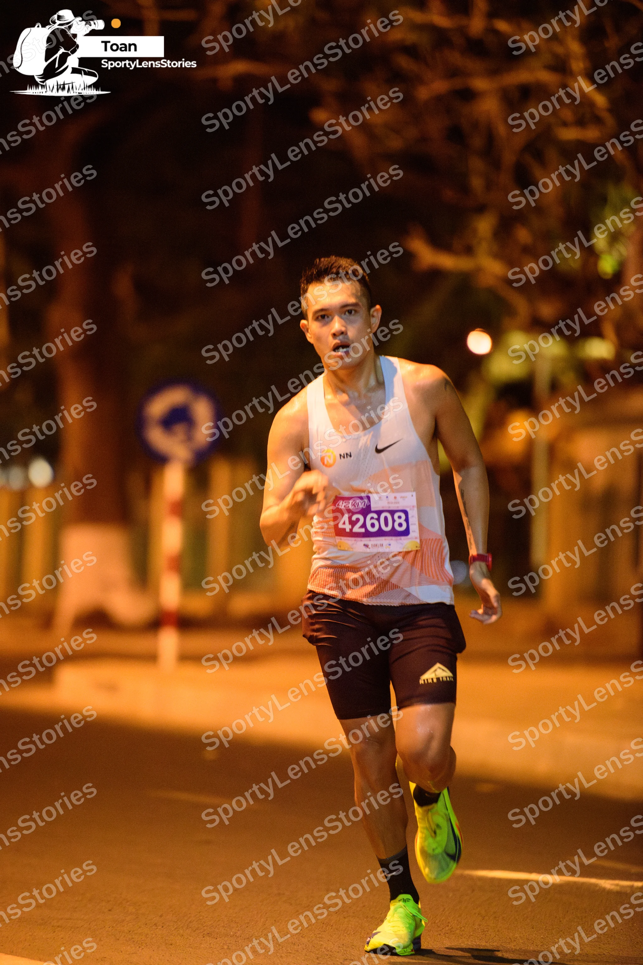 Marathon runner #42608: Runner 1: white tank top, black shorts, neon yellow shoes, wristband