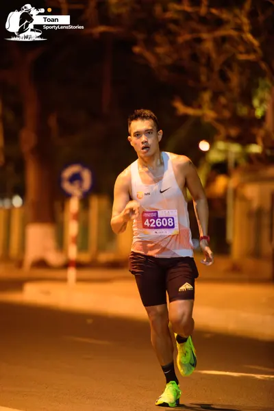 Marathon runner #42608: Runner 1: white tank top, black shorts, neon yellow shoes, wristband