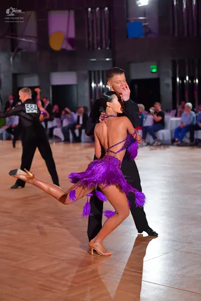 Dancesport competitor #584: Female dancer: purple Latin dress with long fringe