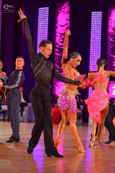 Dancesport competitor: Male dancer 1: black long-sleeved shirt with silver embellishments and black tro