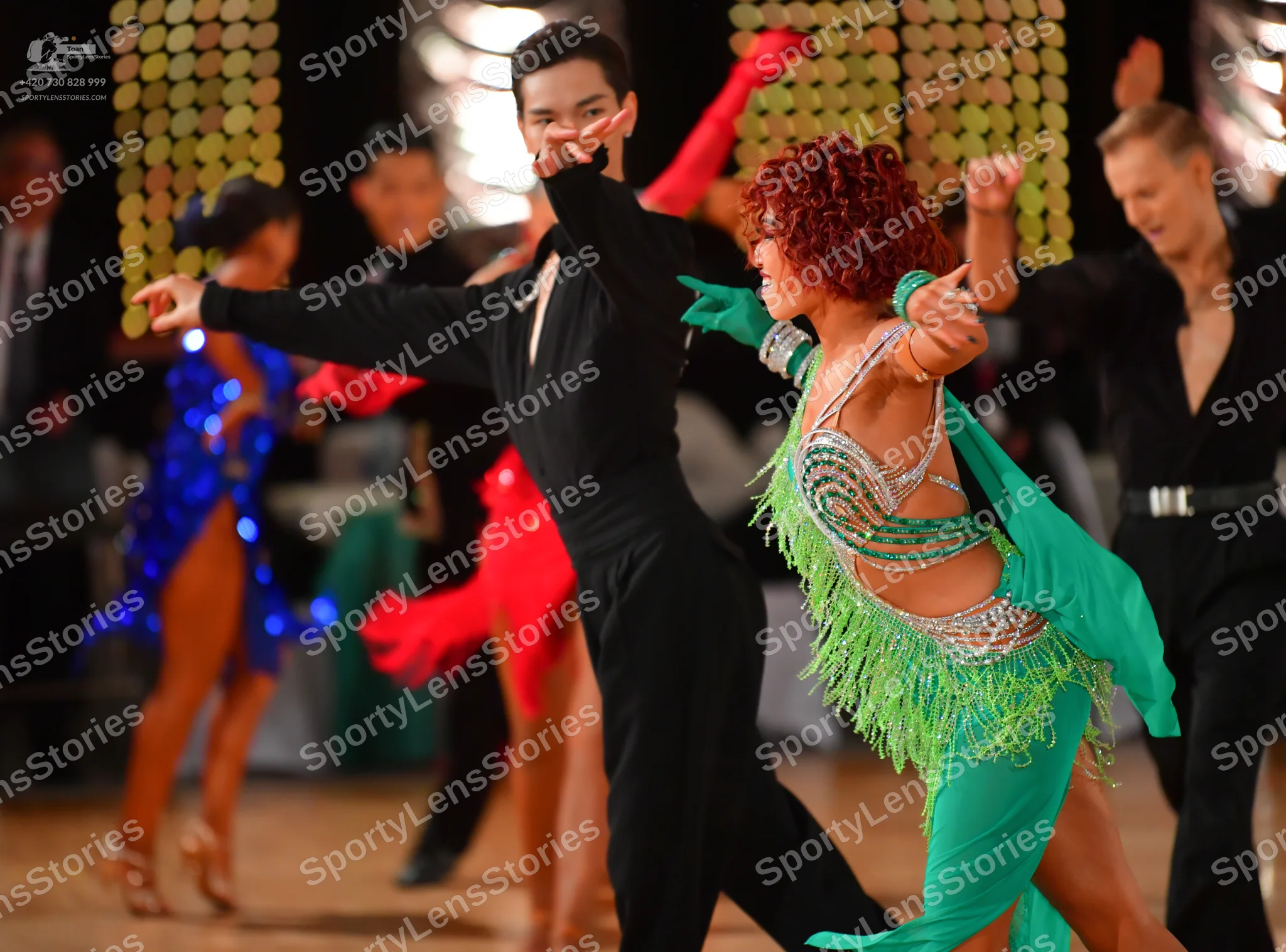 Dancesport competitor: Foreground male dancer: black long-sleeved dance shirt and black trousers