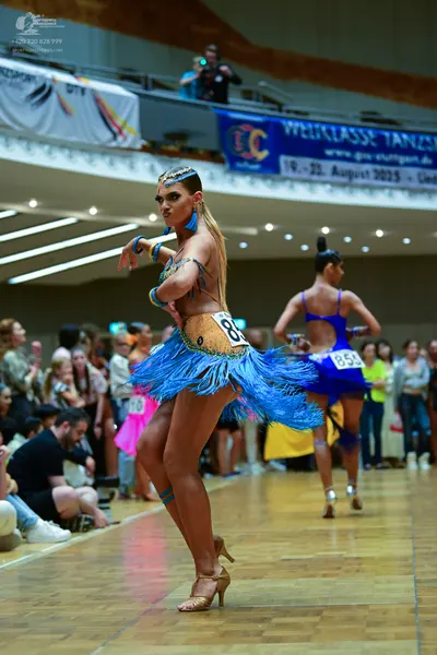 Dancesport competitor #85: Female dancer: tan latin dress with blue fringe and blue accents