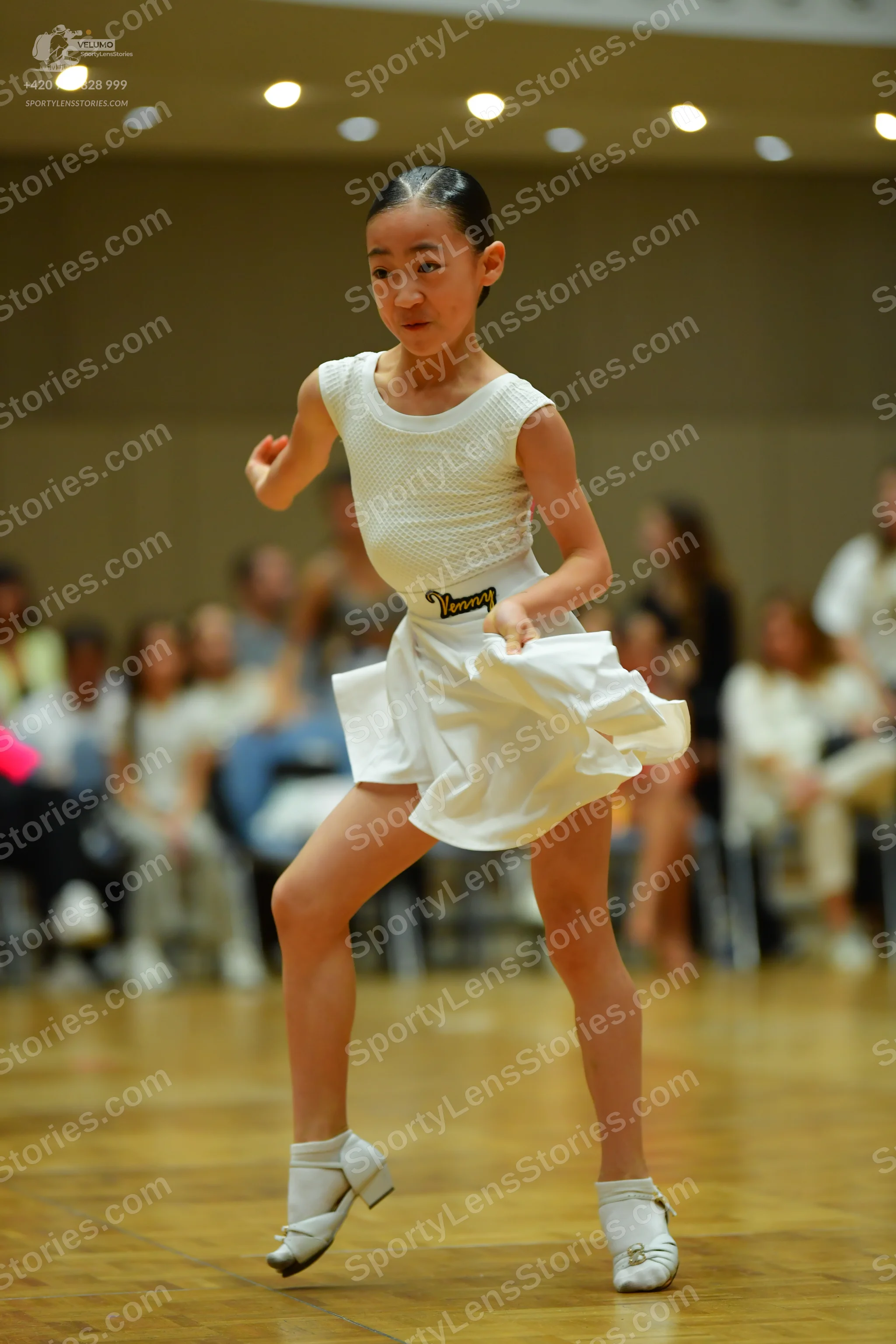 Dancesport competitor: Female dancer: white latin dance costume consisting of a textured sleeveless top