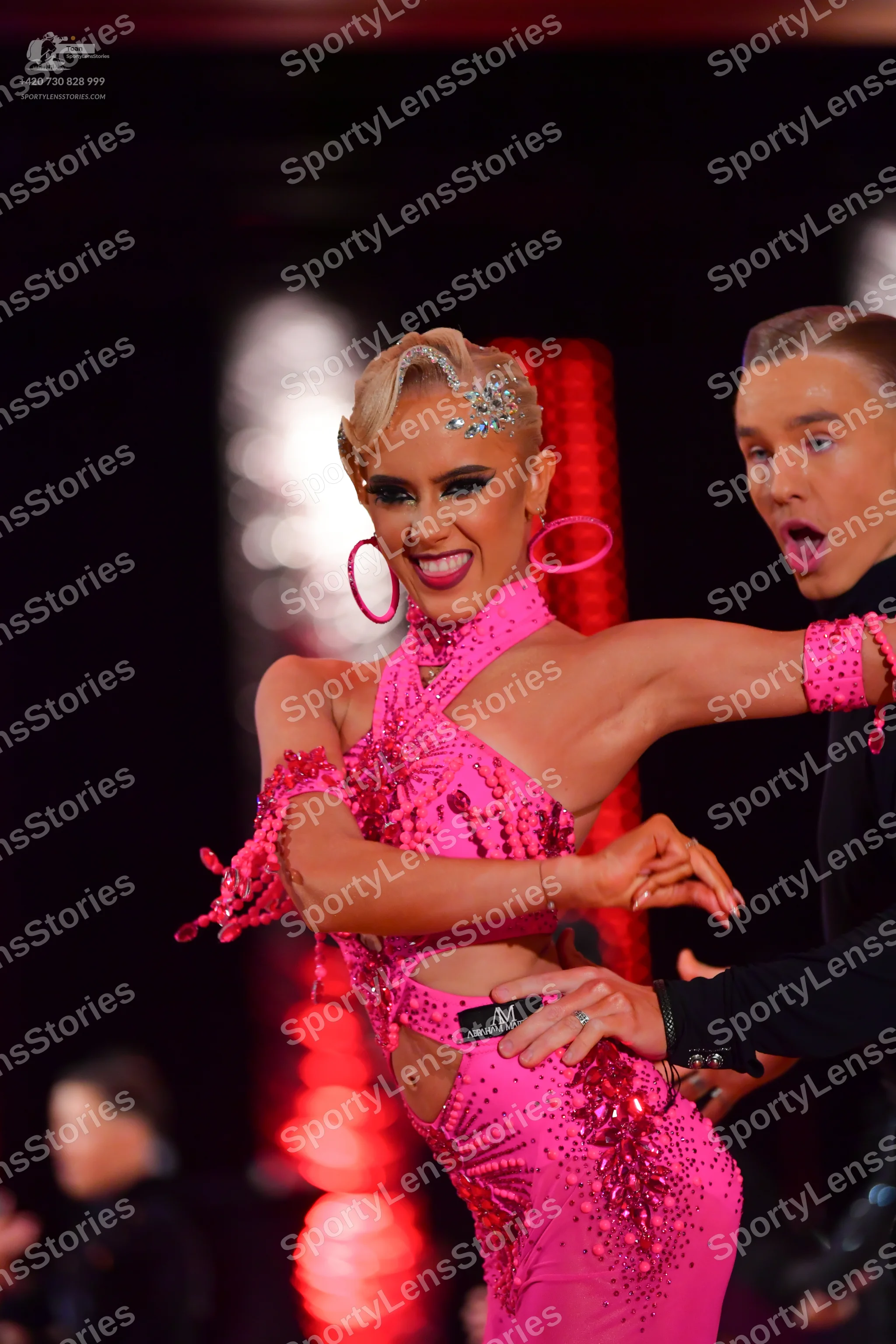 Dancesport competitor: Female dancer: bright pink Latin dress embellished with sequins and beads, featu