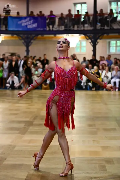 Dancesport competitor: Female dancer: red latin dress with fringe and sequins, featuring matching red a