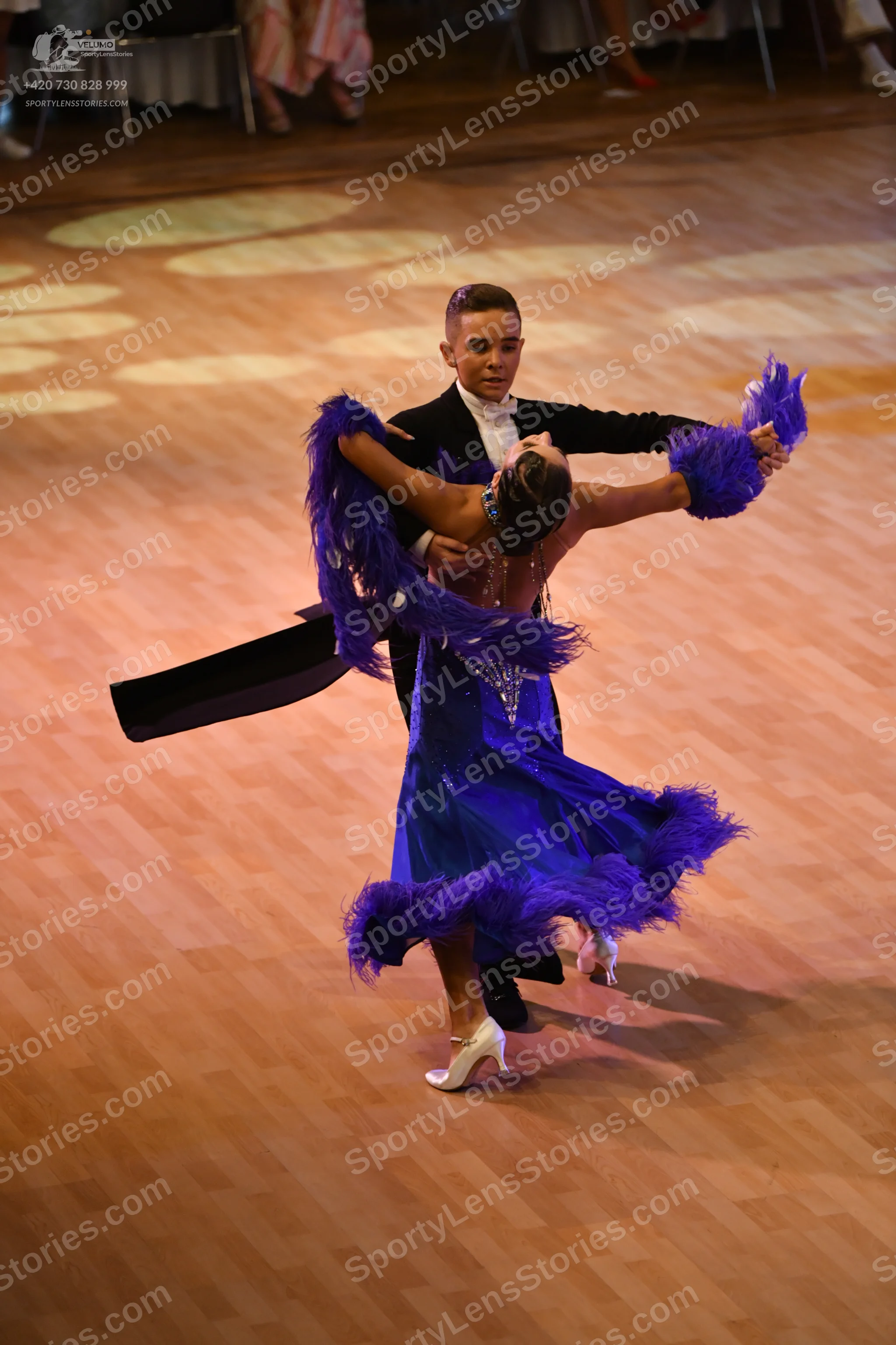 Dancesport competitor: Okay, here’s a detailed description of the dancers' costumes based on the image 