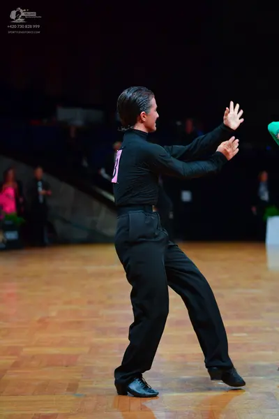 Dancesport competitor: Male dancer: black long-sleeved top and black trousers