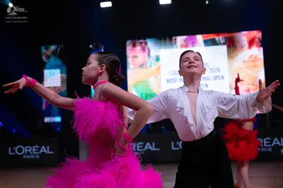 Dancesport competitor: Female dancer: pink Latin dress with large pink feathers and matching pink wrist