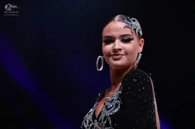 Dancesport competitor: Female dancer: black dress with silver crystal embellishments, wearing large sil